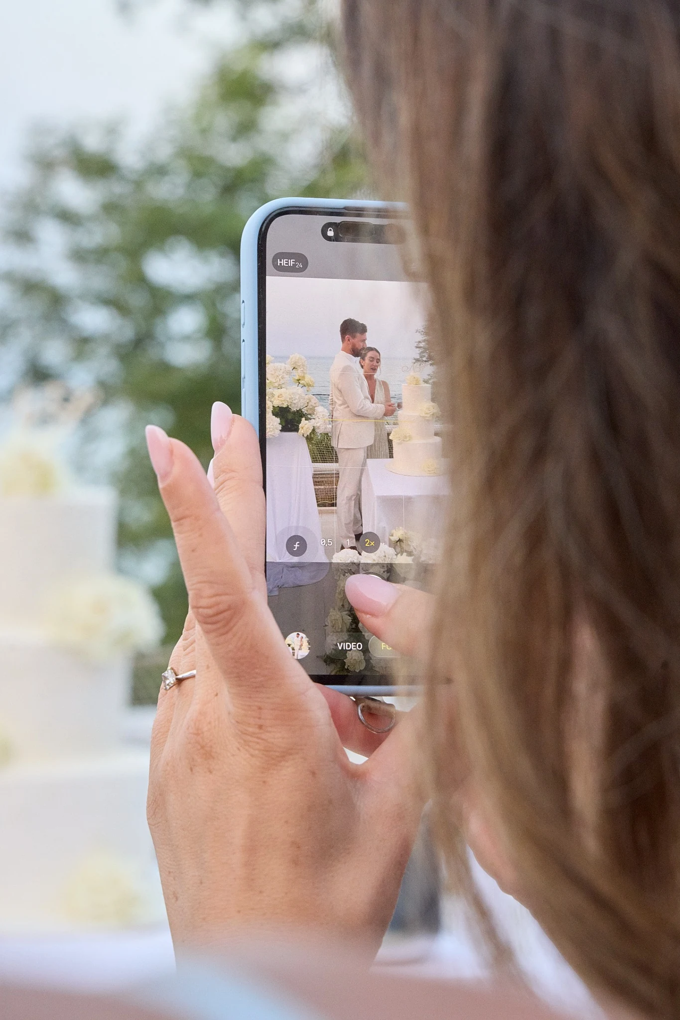 Cake cutting captured on a smartphone during a wedding at Terrazza Setterose