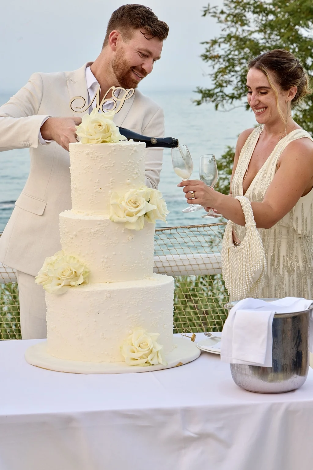 Couple cutting their wedding cake with the Adriatic behind them